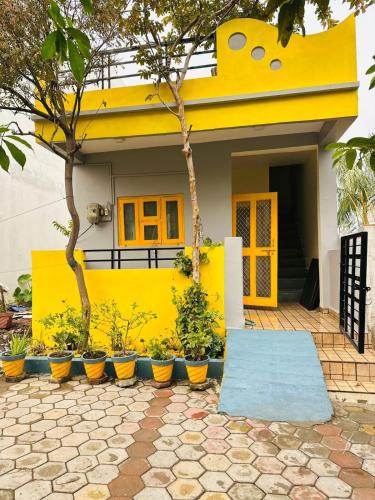 a yellow house with plants inront of it at Badal Homestay 2 Near IIM RRCAT in Indore