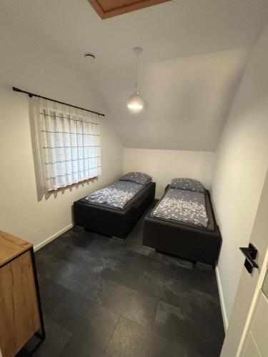 Dos camas en una habitación pequeña con ventana. en Skrzynia, en Skrzynia