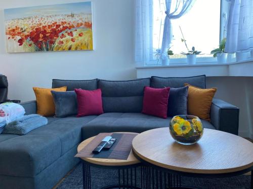 a living room with a blue couch and a table at Apartman 8 Panorama sa garažom in Bjelašnica