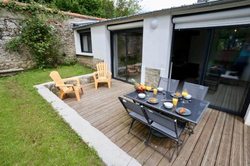 un patio avec une table et des chaises sur une terrasse dans l'établissement Le Forest -4prsT2Terrasse, à Pontivy