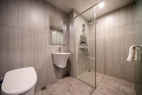 a bathroom with a toilet and a sink and a shower at The Western Busan Hotel By STAYNEO in Busan
