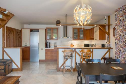une cuisine et une salle à manger avec une table et des chaises dans l'établissement La Petite Maison au calme - 2 chambres - à 200m des Bords de Loire, à Saint-Jean-de-Braye