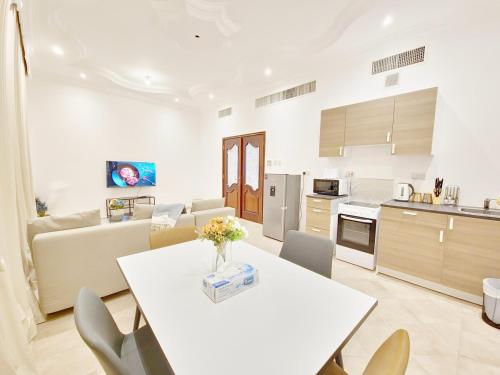 a kitchen and living room with a table and chairs at HARF22G01-011BR Apt in AD in Abu Dhabi