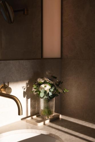 a vase of flowers sitting on a kitchen sink at Almanac Palais Vienna in Vienna