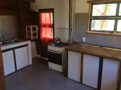 a kitchen with a stove and a sink in it at Cabaña de madera para 4 personas in Playa Hermosa