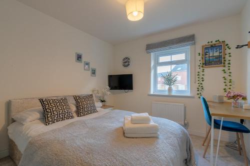 a bedroom with a bed and a desk and a window at Foxglove Haven- 3-Bed Detached - Garden - Drive in Longridge