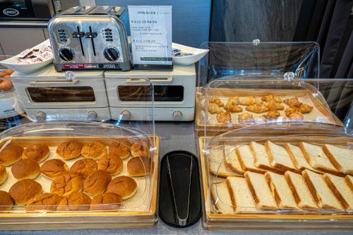 a table topped with trays of bread and pastries at The Western Busan Hotel By STAYNEO in Busan