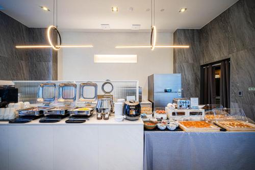 a kitchen with a buffet of food on a counter at The Western Busan Hotel By STAYNEO in Busan