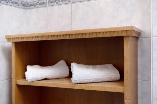 two towels sitting on a wooden shelf in a bathroom at Haus Peer Burgeis in Burgusio