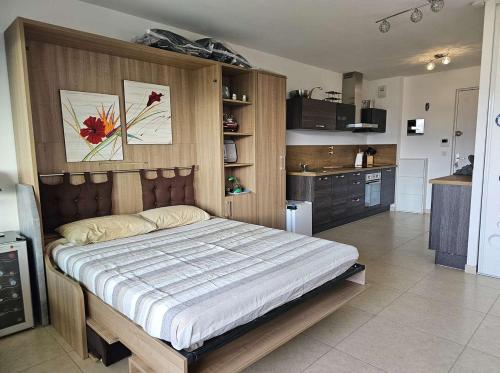 une chambre avec un grand lit et une cuisine dans l'établissement Studio Nautilus N7 proche centre-ville Porto-vecchio, à Porto-Vecchio