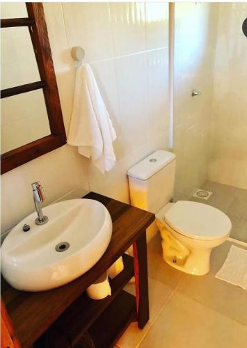 a bathroom with a sink and a toilet at Caminhos da Serra do Tabuleiro - Chalé Araucária in São Bonifácio