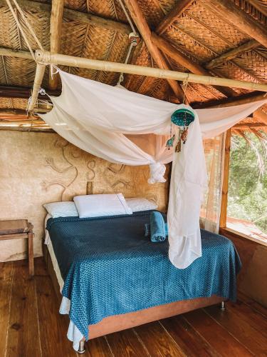 a bed in a room with a mosquito net at Sol de Minca Eco Lodge in Minca
