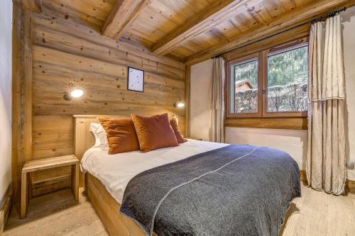 une chambre avec un lit dans une cabane en rondins dans l'établissement Blaitiere 2 Apartment, à Chamonix-Mont-Blanc
