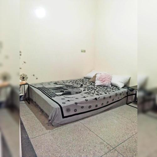 a bed in a room next to a wall at Private Room - 23 Min to Airport - 20 Min to Agadir Beach - Near Golf, Medina, Markets & Inezgane Taxi Station for Nearby Visits and City-to-City Travel in Inezgane
