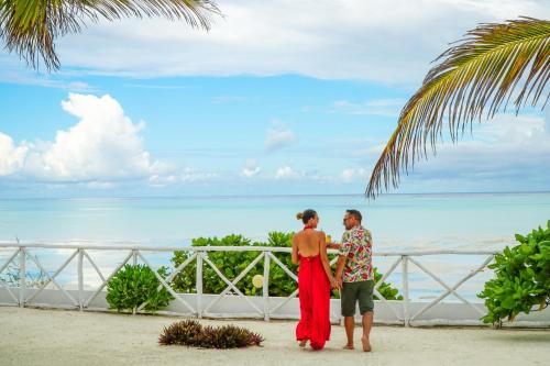 a man and woman standing on a balcony looking at the ocean at Aquamarina Hotel in Jambiani