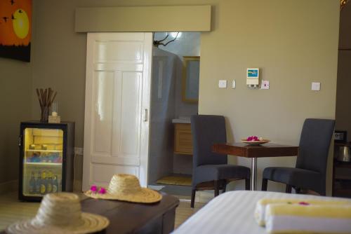 a room with a room with a table and chairs at Aquamarina Hotel in Jambiani