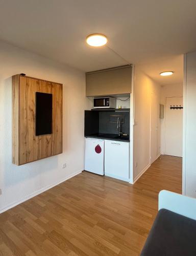 un salon vide avec une petite cuisine avec un comptoir dans l'établissement Studio à Guzet Neige aux pieds des Pistes et de Ecole de Ski, à Ustou