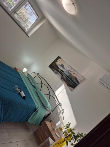 a bedroom with a blue bed and two windows at Le Mimose Holiday House di Como - Grandate in Grandate