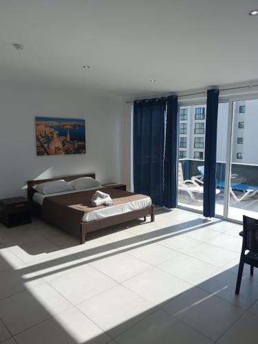 a bedroom with a bed and a large window at Magnolia Guest House in St. Julianʼs