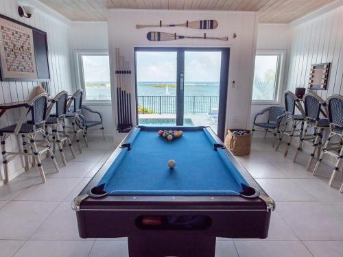 a pool table in a room with chairs at The Seahouse Antigua SEAFRONT in Bats Cave
