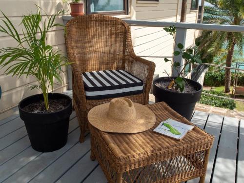 a straw hat sitting on a wicker chair on a porch at The Seahouse Antigua SEAFRONT in Bats Cave