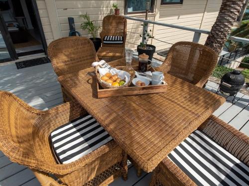 a wooden table with a basket of fruit on a patio at The Seahouse Antigua SEAFRONT in Bats Cave