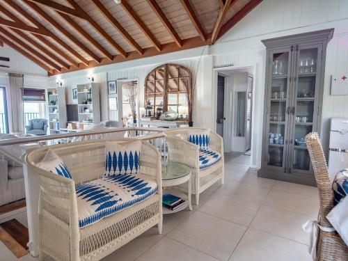 a dining room with wicker chairs and a table at The Seahouse Antigua SEAFRONT in Bats Cave