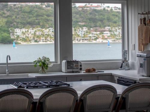 a kitchen with a table with a view of the water at The Seahouse Antigua SEAFRONT in Bats Cave