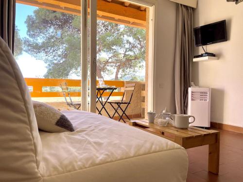 une chambre avec un lit et un balcon avec une table dans l'établissement Appart 4pers - vue imprenable, à Fitou