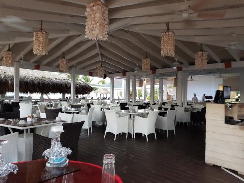 a dining room with white tables and chairs at 2BR Beachfront Unit w View - 62 in Bayahibe