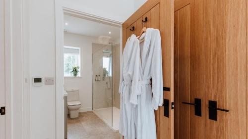 a bathroom with a robe hanging on a door at The Piggery in Yarpole