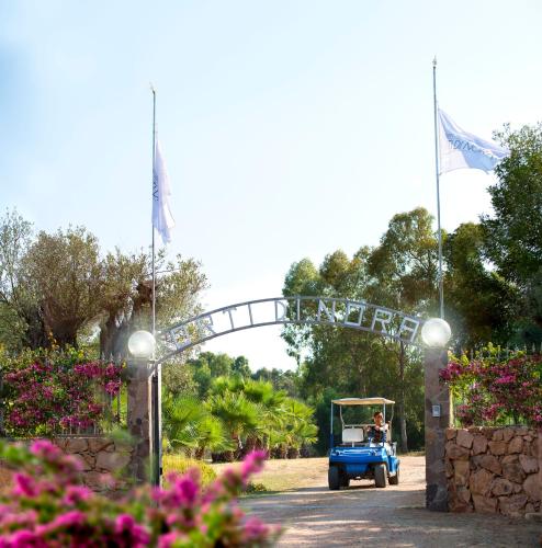 a man driving a blue truck under a bridge at Hotel Rurale Orti di Nora & SPA in Santa Margherita di Pula