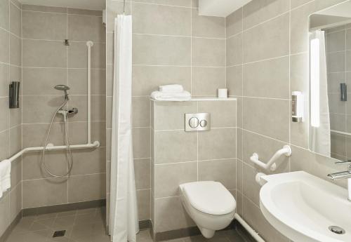 a bathroom with a shower and a toilet and a sink at B&B HOTEL Marne-la-Vallée Val d'Europe in Serris