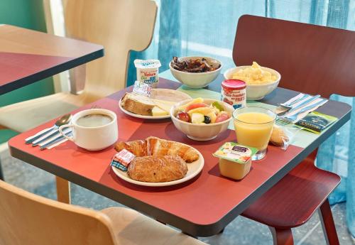 a table with breakfast foods and drinks on it at B&B HOTEL Marne-la-Vallée Val d'Europe in Serris