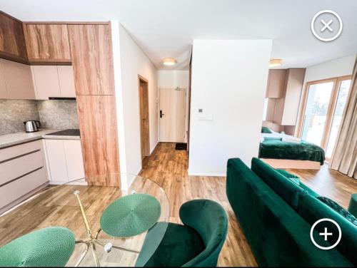 a living room with a green couch and a kitchen at Apartmán Esprit Y31 in Dolný Kubín