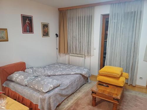 a small bedroom with a bed and a table at Milutin in Pale