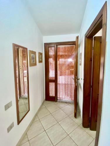 a hallway with two doors and a tile floor at Casa Perassi in Putzu Idu