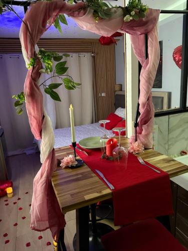 une table avec un chiffon de table rouge et une bougie dans l'établissement Love room nantais, à Nantes