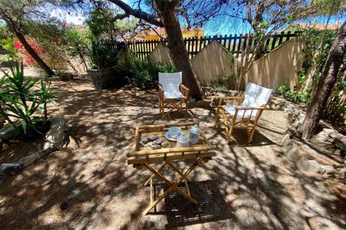 a patio with two chairs and a table and two chairs at Casa Perassi in Putzu Idu
