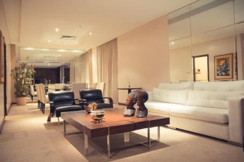 a living room with a white couch and chairs at Crowne Plaza Asunción by IHG in Asuncion