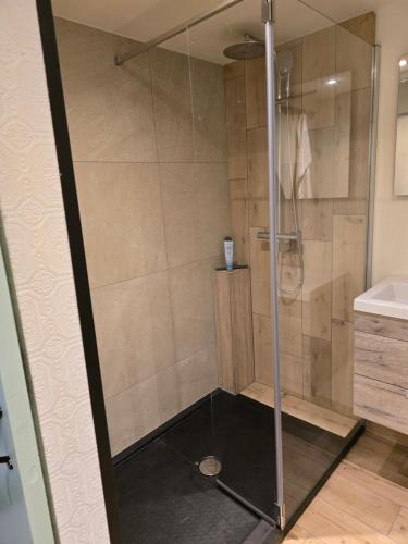 a shower with a glass door in a bathroom at Huma2025 in Eede