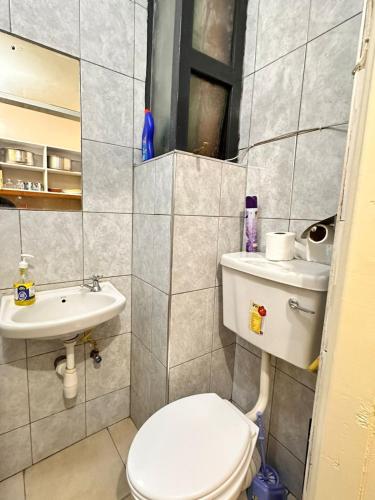 a small bathroom with a toilet and a sink at Residence Next Door Coral Mega in Kiambu