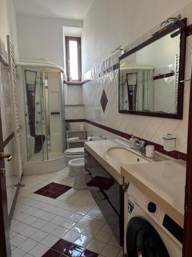 a bathroom with a sink and a toilet and a mirror at Vistadamare in Nettuno