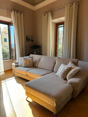 a living room with a couch and some windows at Vistadamare in Nettuno