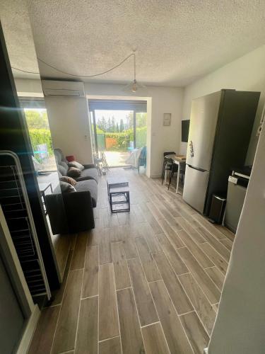 - un salon avec un canapé et un réfrigérateur dans l'établissement Studio proche mer avec jardinet, aux Lecques