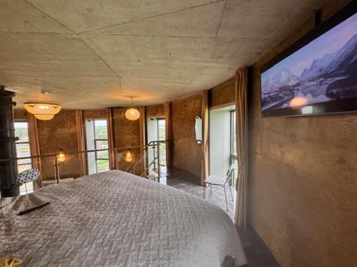 a bedroom with a large bed and a flat screen tv at Watertorenhotel WADHOOG in Sint Jacobiparochie