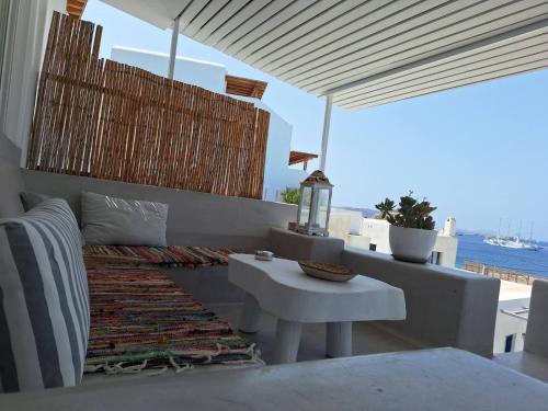 a patio with a white table and a view of the ocean at Mykonos Seaview Nests - Tourlos Getaways in Tourlos