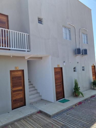 a white building with two doors and a staircase at Pousada Aconchego Vitória in Parnaíba