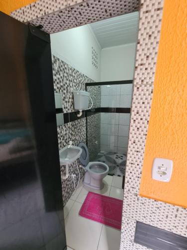 a small bathroom with a toilet and a sink at Hospedagem e queijaria Péua in Soure