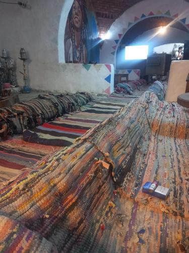a row of carpets in a room with a mural at Noupian mother in Aswan